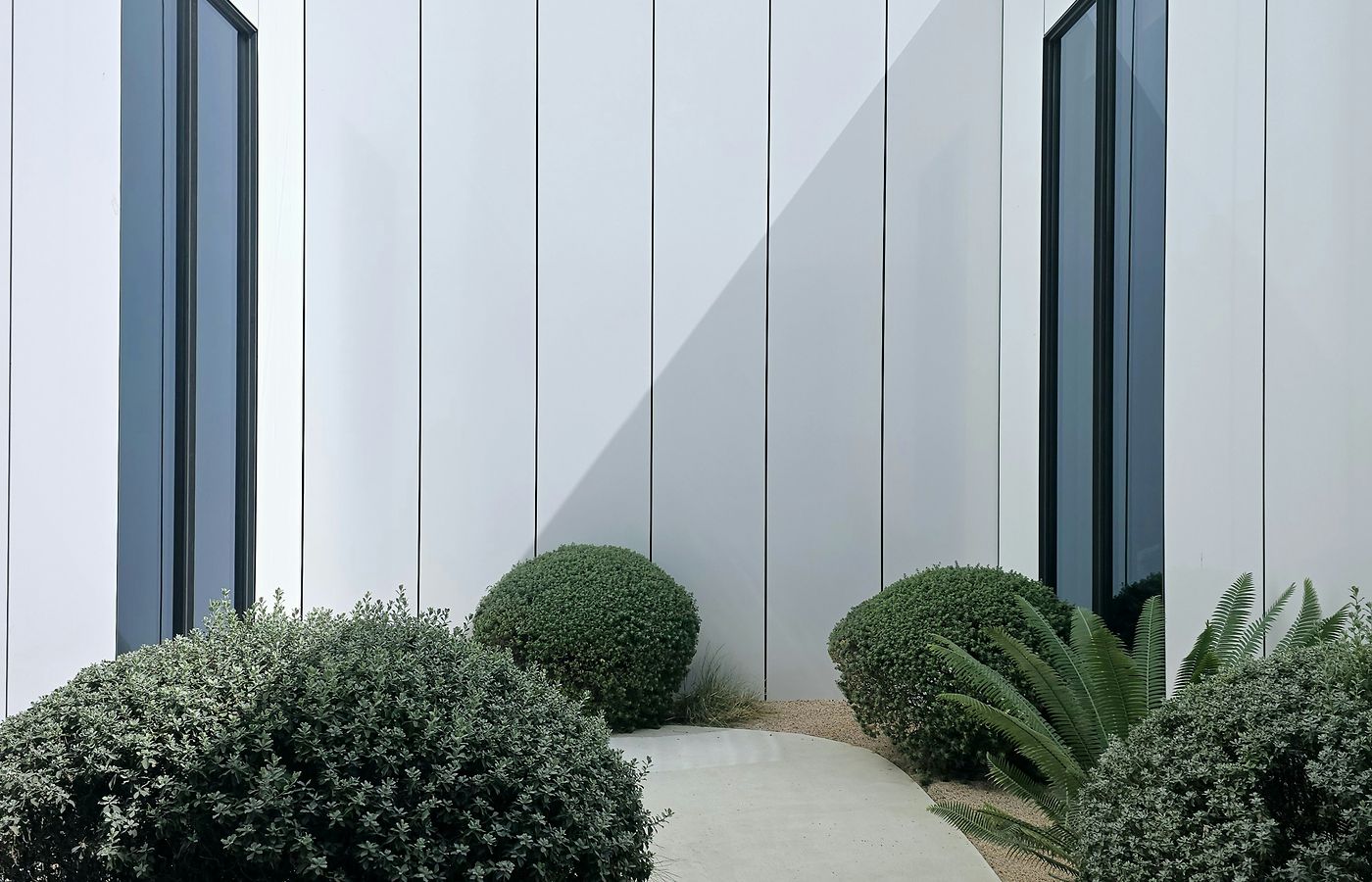 Landscaped pathway beside a modern building in Dubai